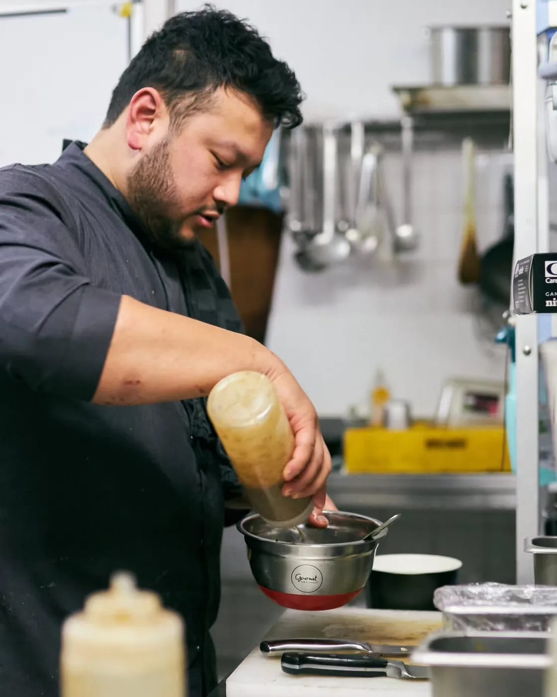 Le chef dresse l'assiette et nappe la sauce montée minute